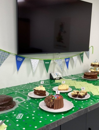 Macmillan coffee morning stand with various cakes on it.