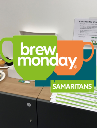 A background of a cakes and biscuits stand with a Brew Monday Samaritans on top of the background.