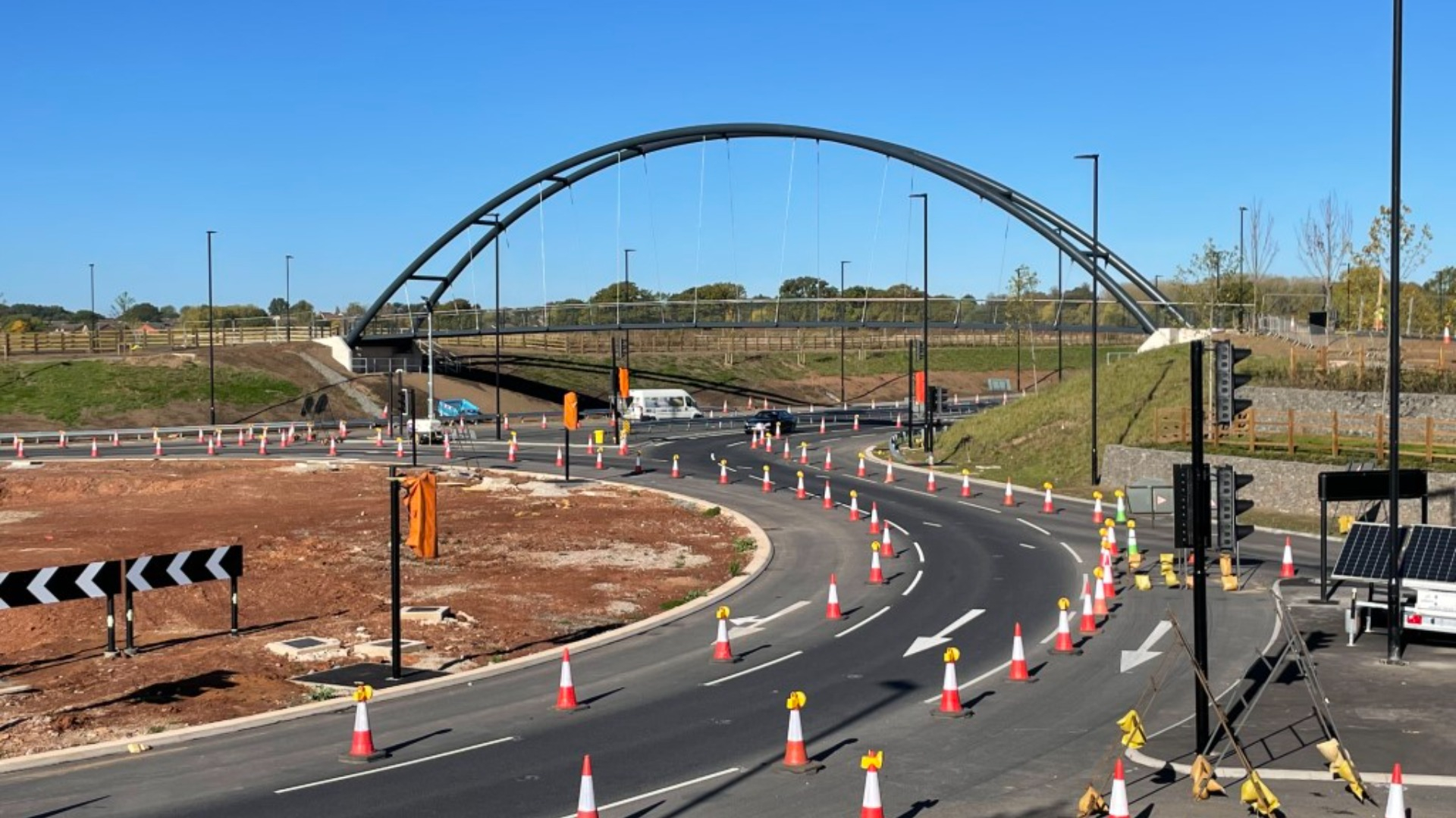 Large roundabout under construction with a bridge going over one of the exit roads.